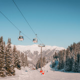 La télécabine de Vizelle passe au dessus d'une piste où des skieurs descendent