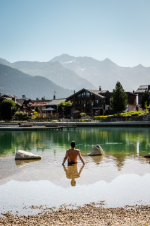 Une personne  est assise dans l'eau au bord du lac