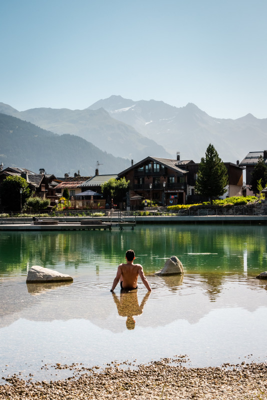 Une personne  est assise dans l'eau au bord du lac